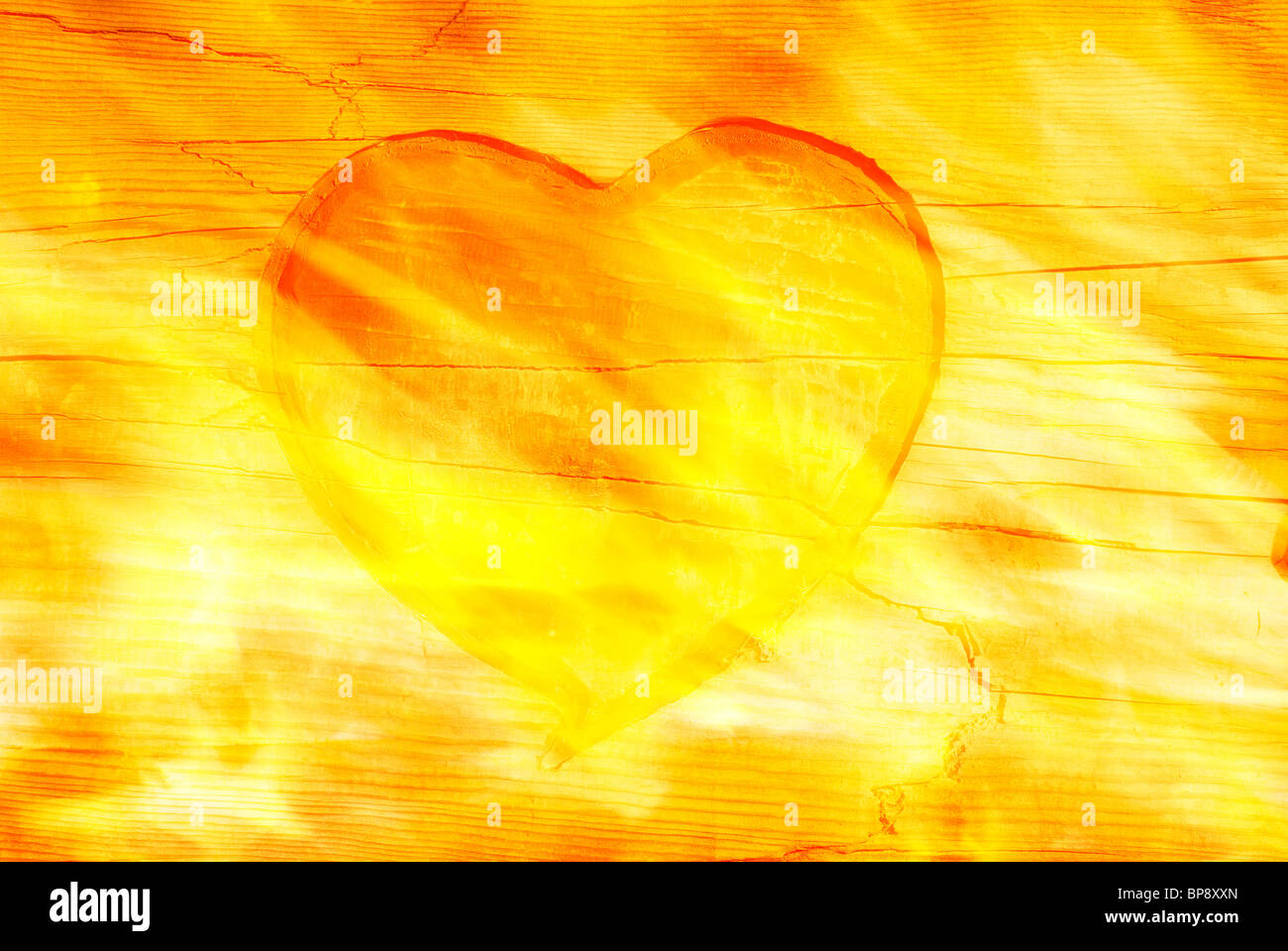 Burning heart. Red heart pattern engraved on old wood with fire. textured effect. Stock Photo