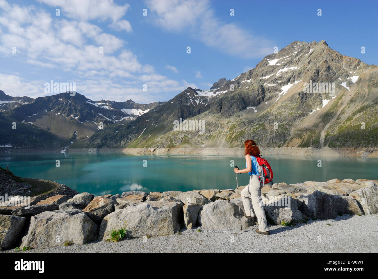 Female hiker looking over reservoir Finstertal, Sellrain, Stubai Alps, Tyrol, Austria Stock Photo