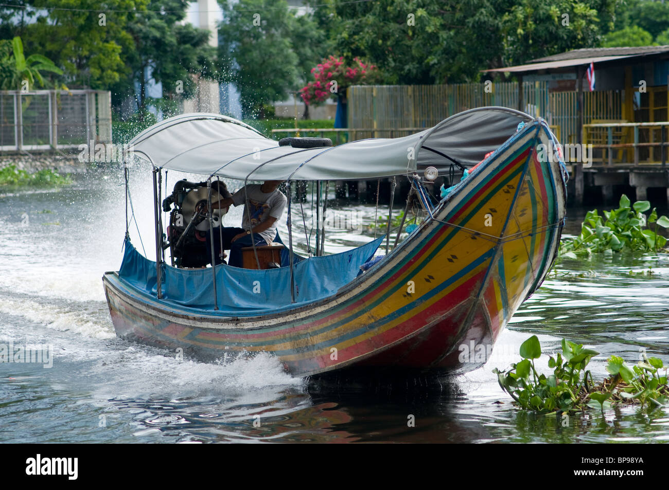 Longtail boat at speed on a canal in Bangkok, Thailand. Stock Photo