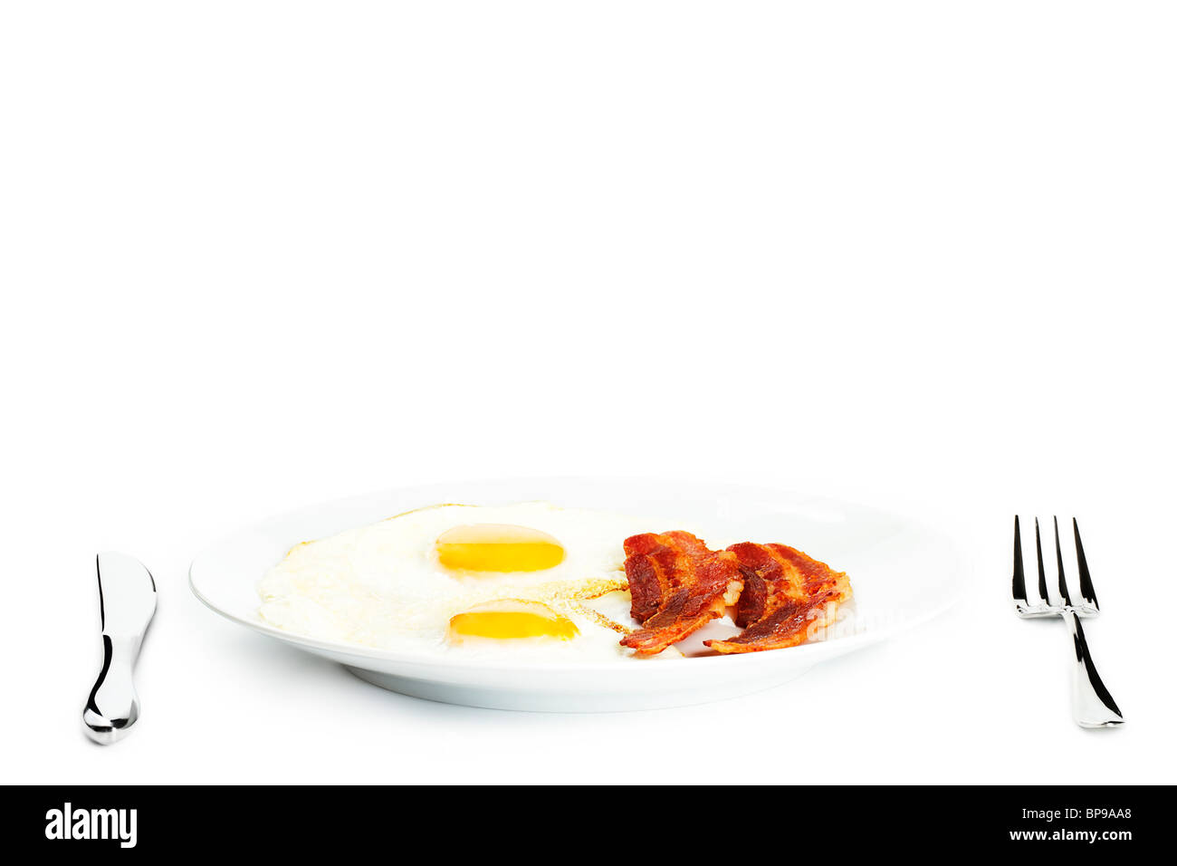 fried eggs and bacon on a plate on white background Stock Photo - Alamy