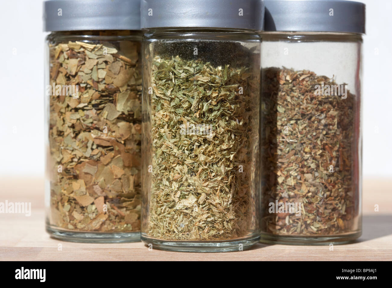 containers of different dried herbs including bay leaves parsley and