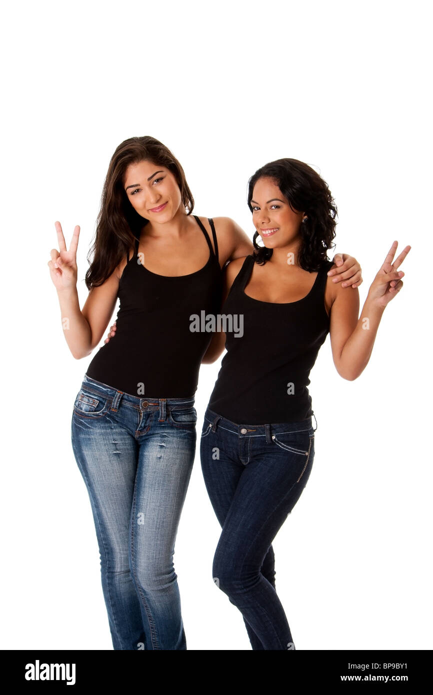 beautiful happy smiling young women couple friends making peace victory gesture with fingers while hugging each other. Stock Photo
