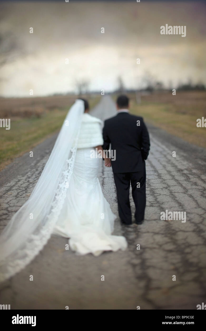 ontario, canada; a bride and groom walking down a road together Stock Photo