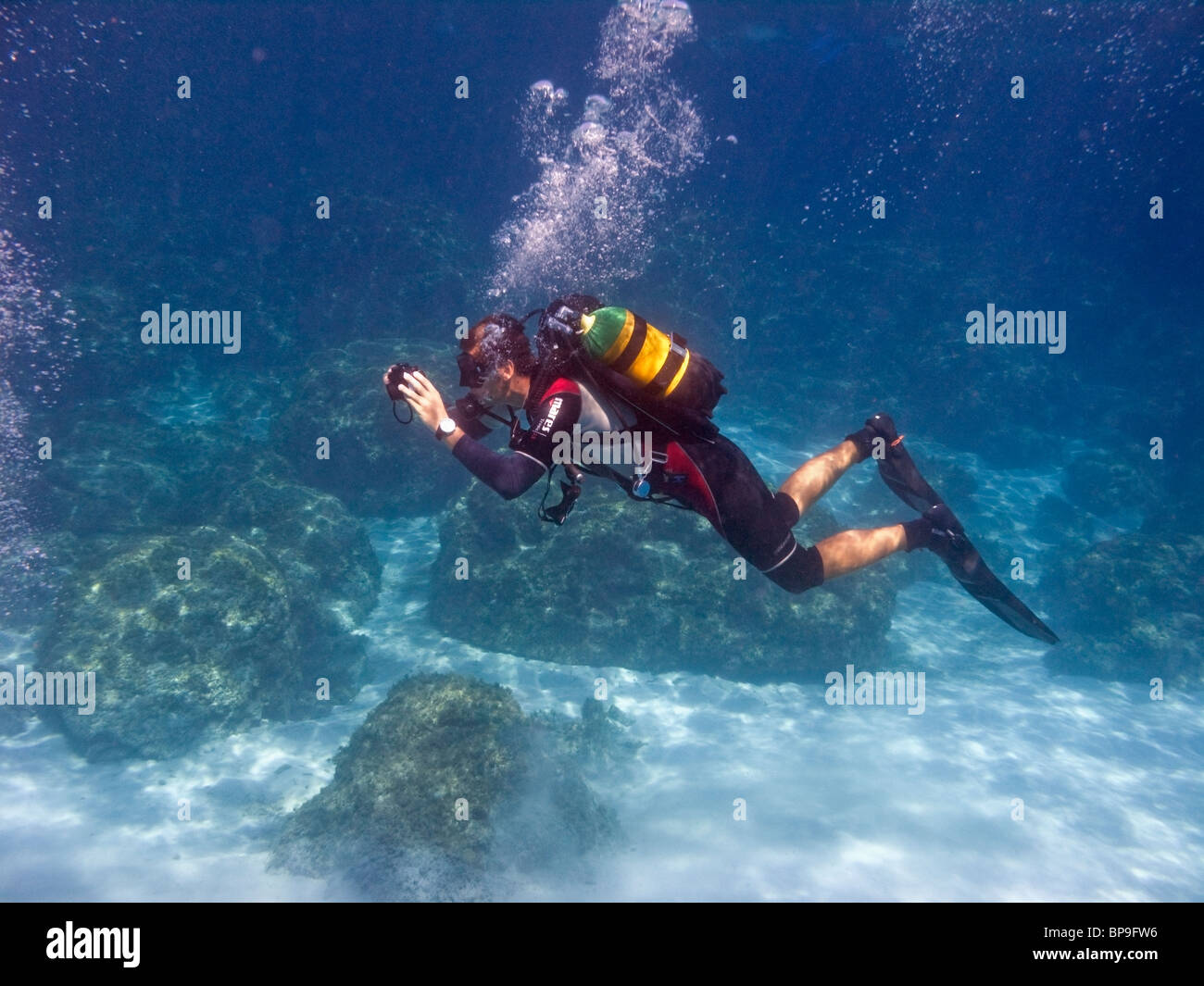 A scuba diver instructor is taking underwater photos of his pupils. The Blue Lagoon, near Cape Greco, Cyprus, Europe. Stock Photo