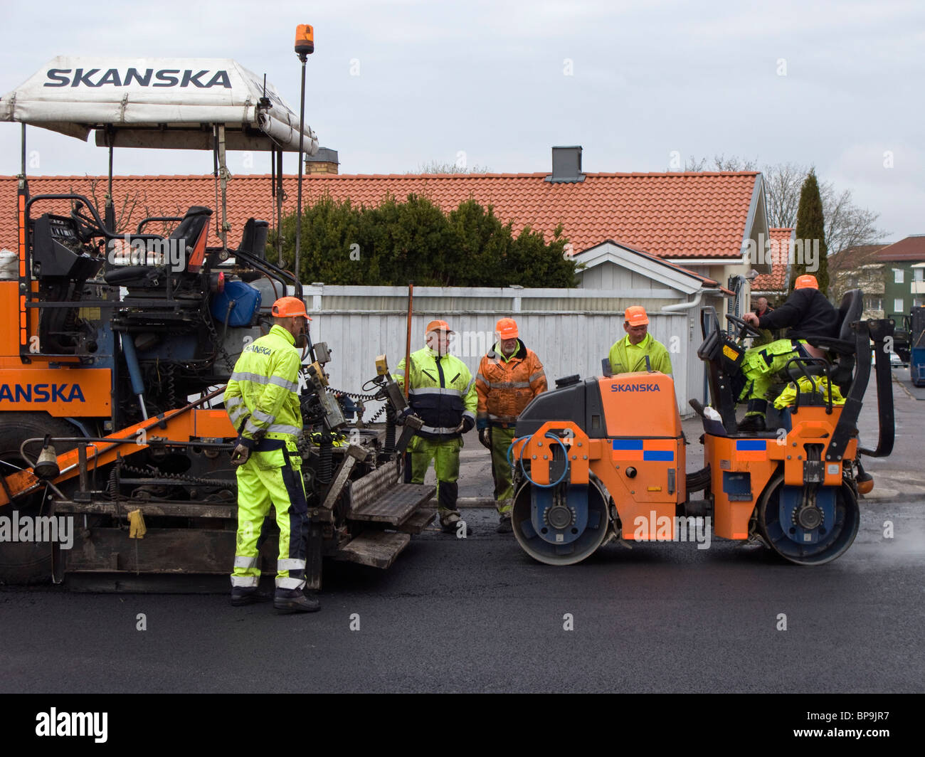 Road roller making the asphalt flat, hard and compact. Stock Photo