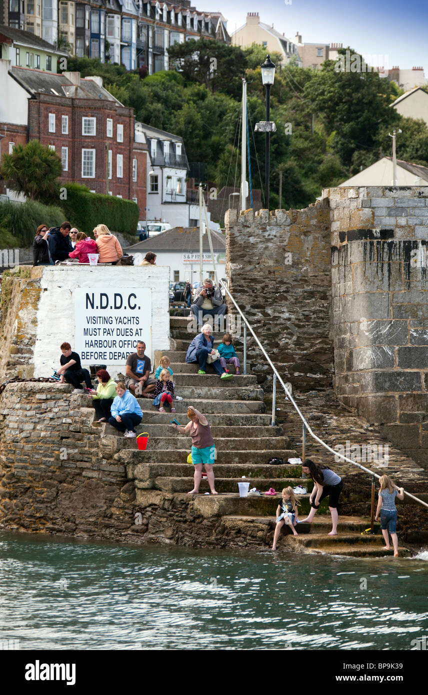Holiday makers on the steps of Ilfracombe harbour fishing for crabs Stock Photo