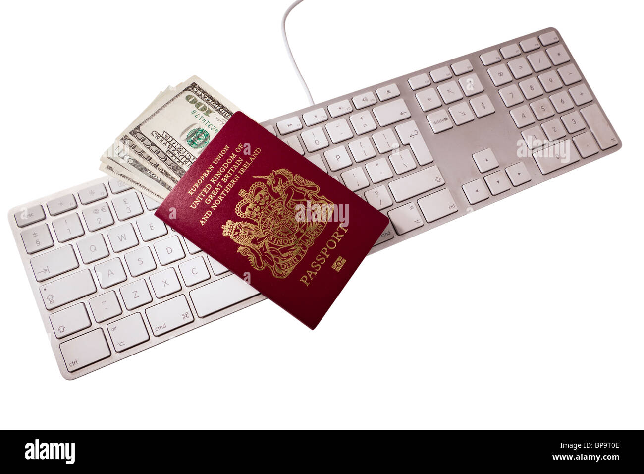 Passport with dollar bills inside on a computer keyboard Stock Photo