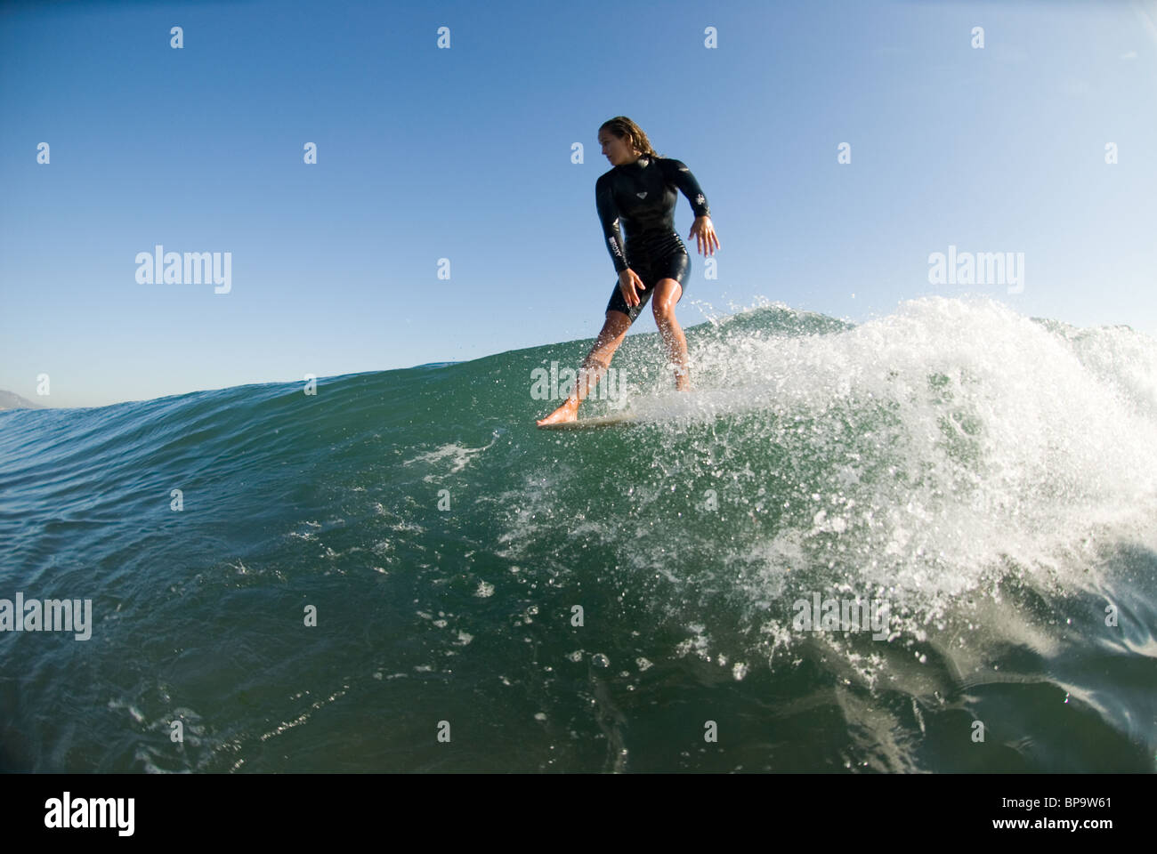 A female surfer hangs five while surfing Malibu, California, USA. Stock Photo