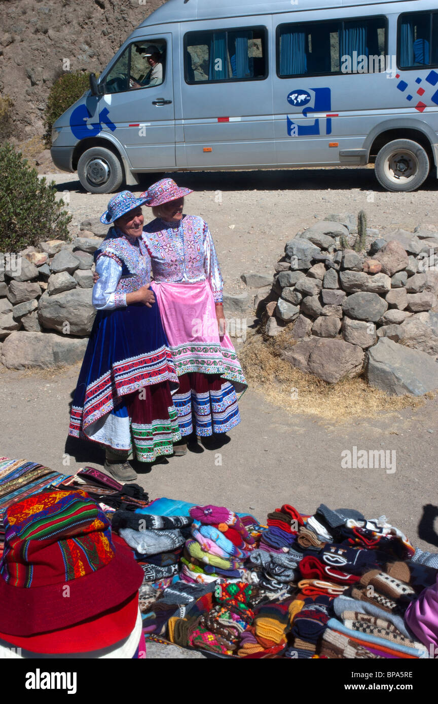 Western tourists wear local costumes at a lookout point in the Colca Canyon, Peru. Stock Photo