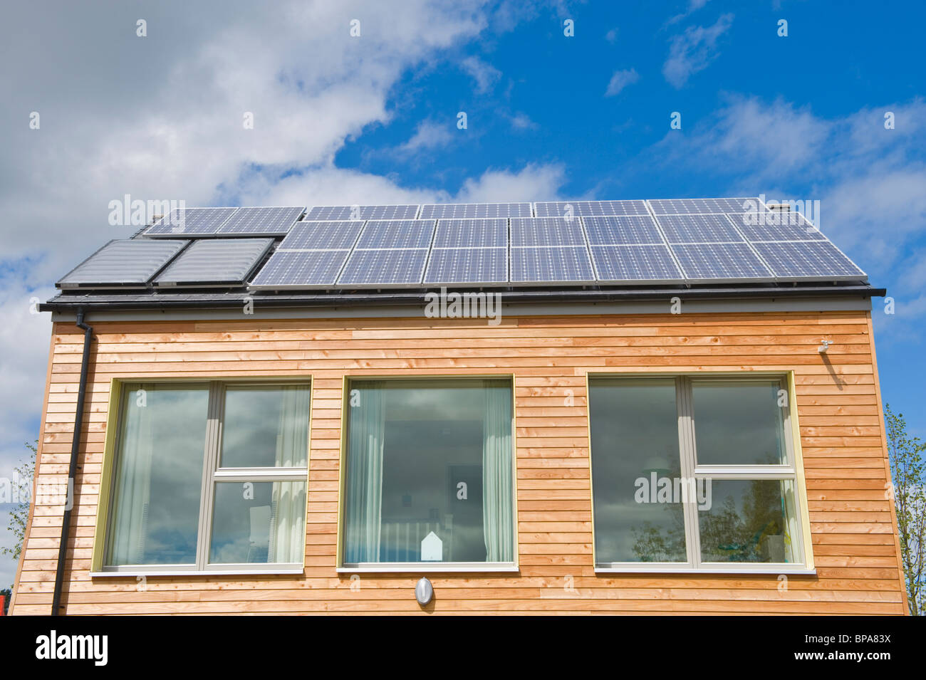 Timber clad zero carbon passive house with triple glazed windows & roof covered with solar panels for electricity and hot water Stock Photo