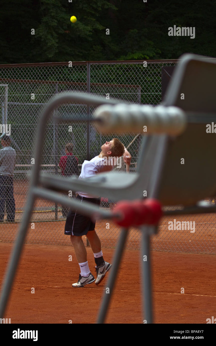 Tennis player serving. Seen through the referee chair. Portrait Stock