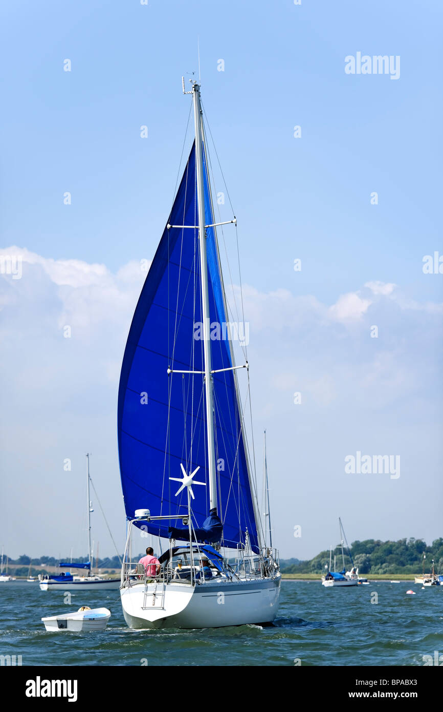 Blue sails - Sailing boat on the estuary Stock Photo