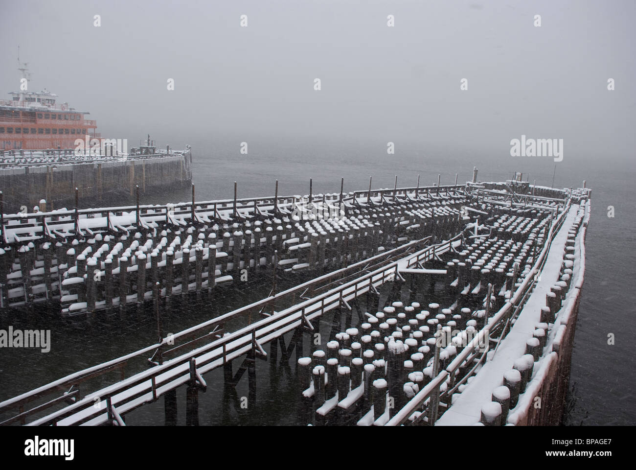 Snow capped barrier pilings at the South Port Ferry slip on winter day in Manhattan New York Stock Photo