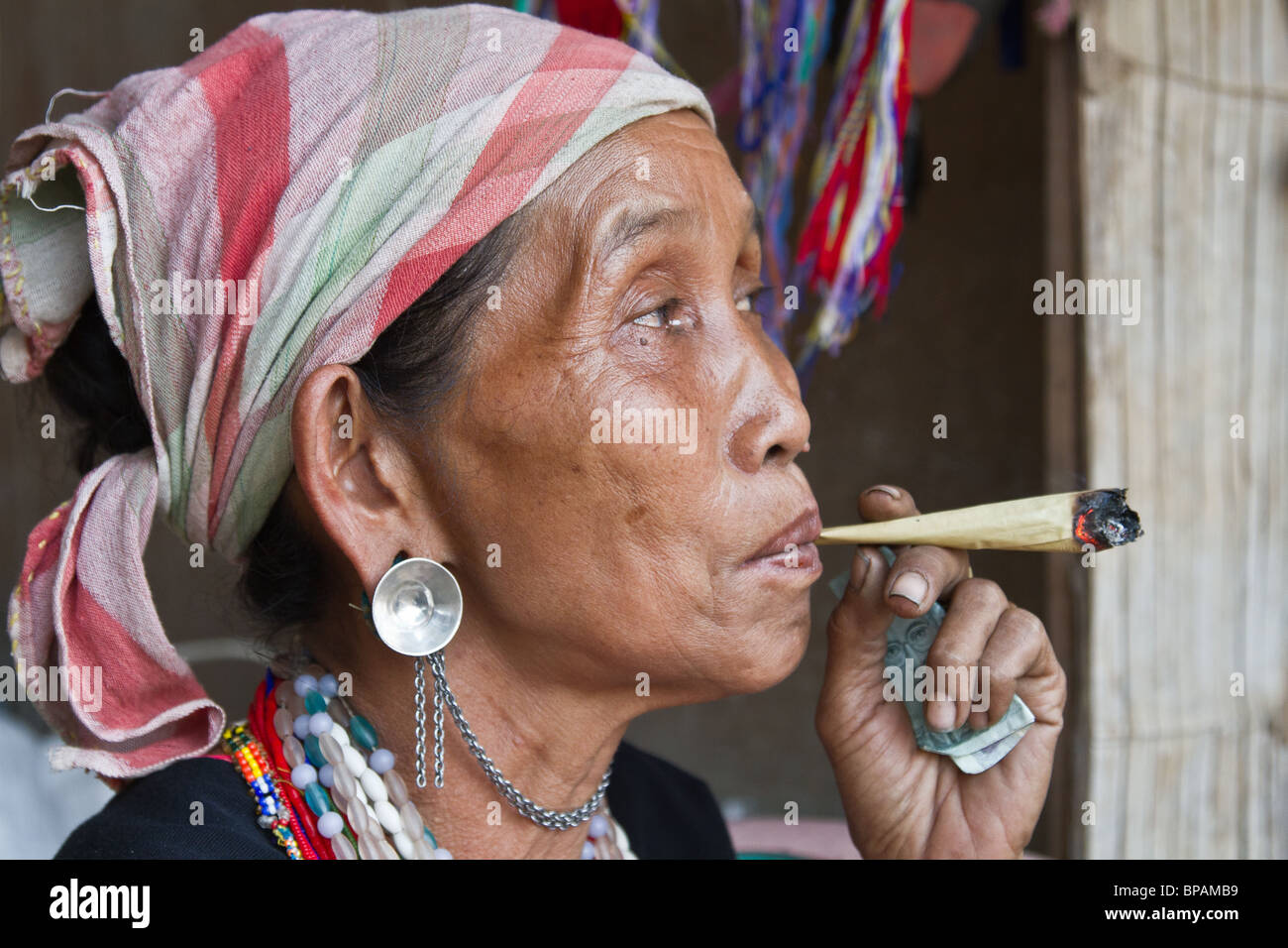 minority woman smokes a homemade cigarette Stock Photo