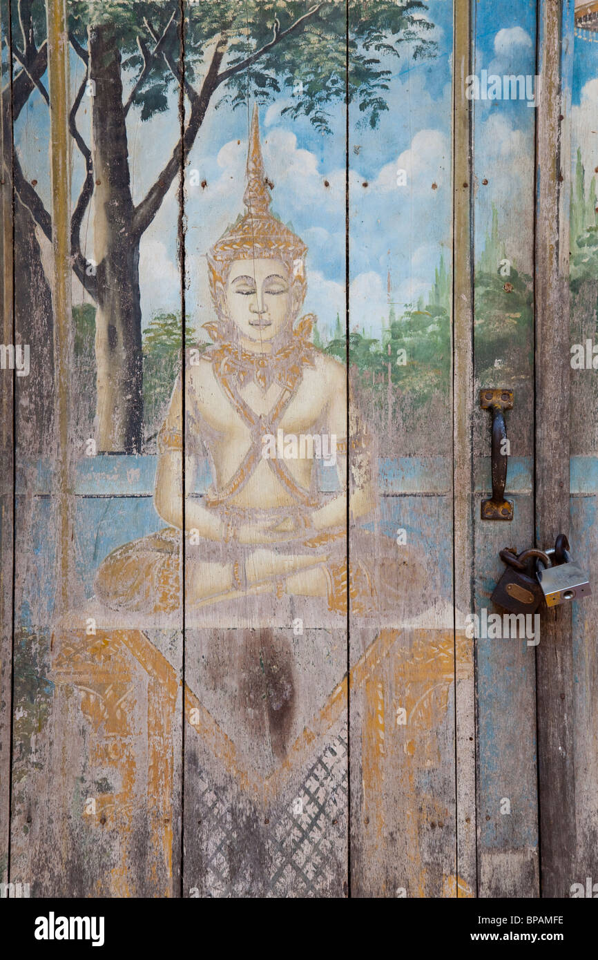 Old Buddha painting on a wooden pagoda door - Phnom Penh, Cambodia Stock Photo