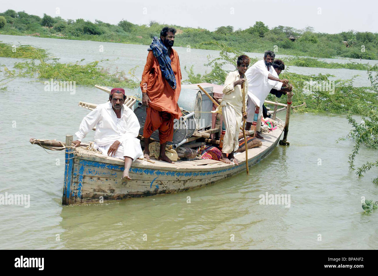 Flood affectees with their household travel on a boat to move towards safe place from Darya Khan village in Thatta Stock Photo