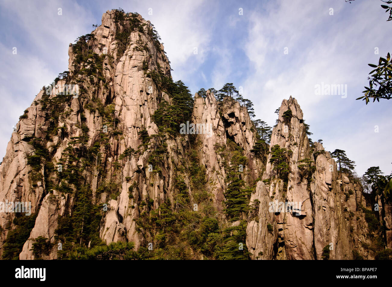 View of mountains against a blue sky with some clouds from the Huang Shan (Yellow Mountains) area in China. Stock Photo