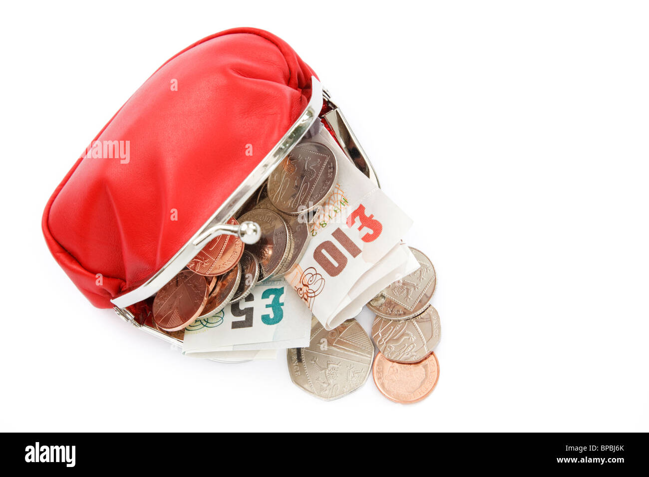 Isolated coin sterling money open red purse containing ten and five British pound notes GBP with some cash coins spilling out from above. England UK Stock Photo