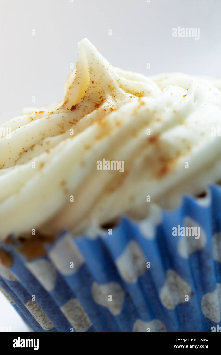 A cupcake cream cheese icing topped with cinnamon. Stock Photo