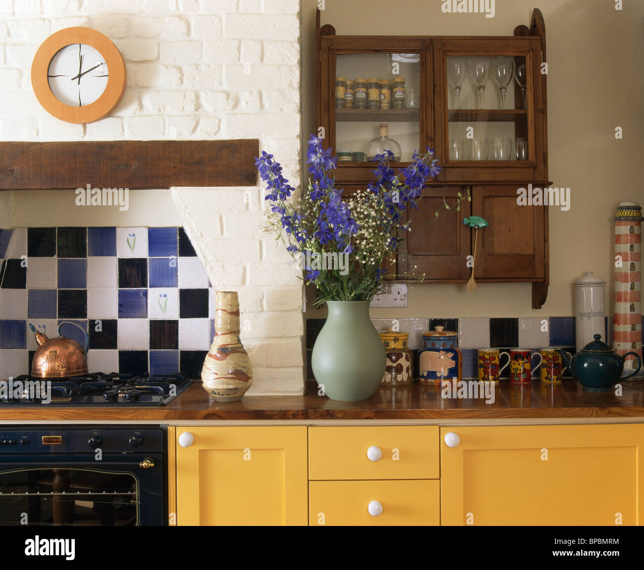 https://c8.alamy.com/comp/BPBMRM/small-antique-shelf-unit-on-wall-above-vase-of-blue-flowers-on-worktop-BPBMRM.jpg