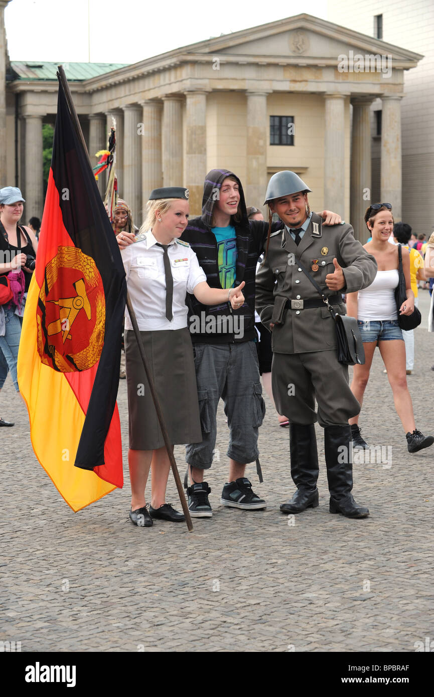 Young male paying to have photograph taken man in GDR Uniform The Brandenburg Gate Berlin Germany Deutschland Europe Stock Photo