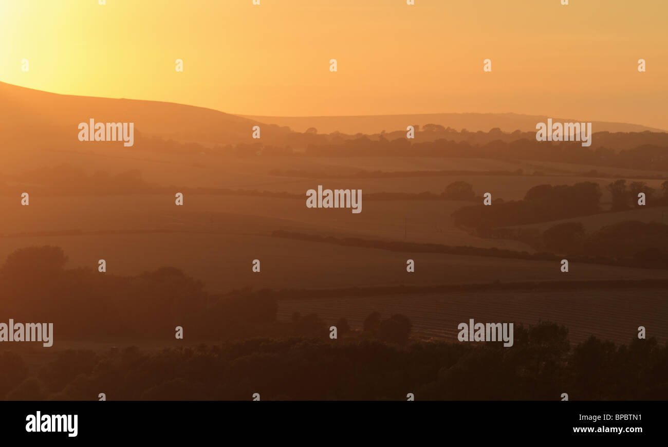 The sun sets behind Firle Beacon, in the South Downs National Park, East Sussex, England. Stock Photo