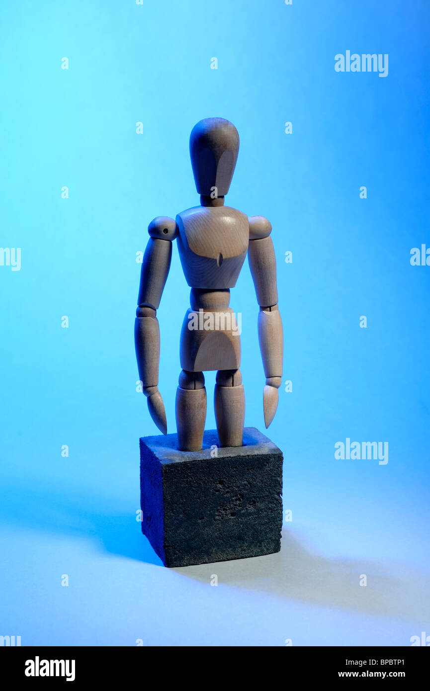 Wooden mannequin with feet set in concrete Stock Photo