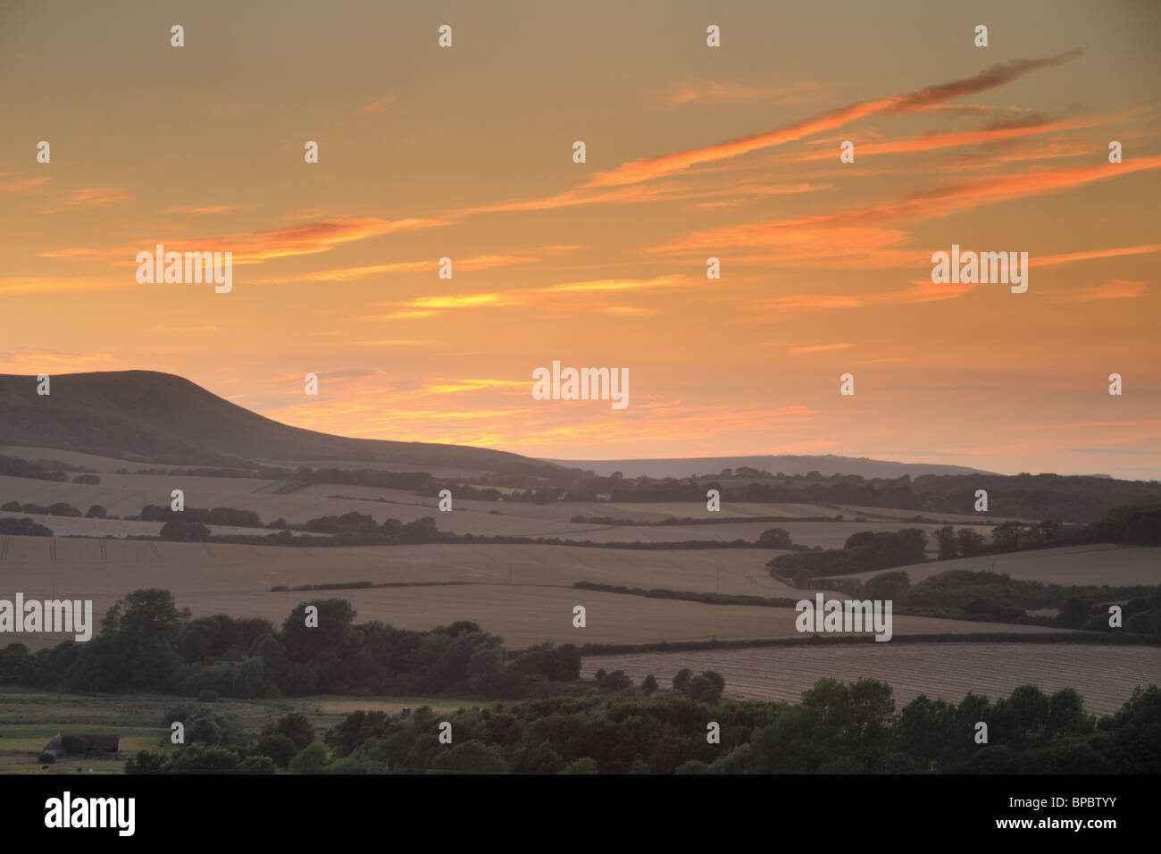 The sun sets behind Firle Beacon, in the South Downs National Park, East Sussex, England. Stock Photo