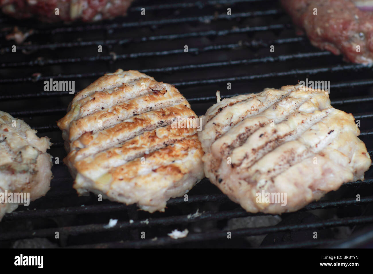 Chicken burgers on a charcoal grill Stock Photo Alamy