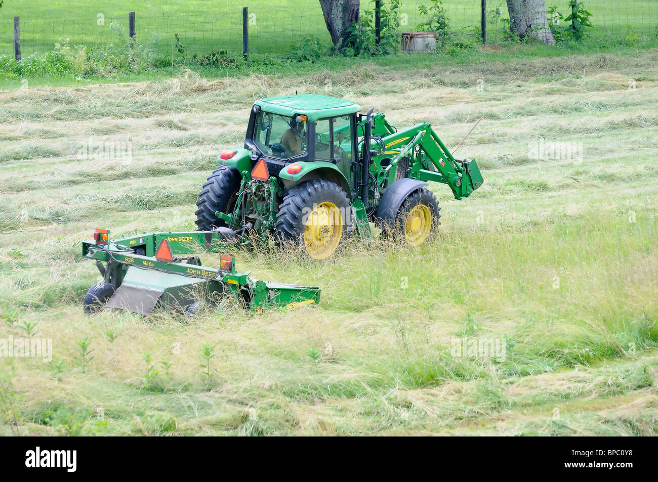 Tractor cutting hay in a field in Kentucky, USA Stock Photo Alamy