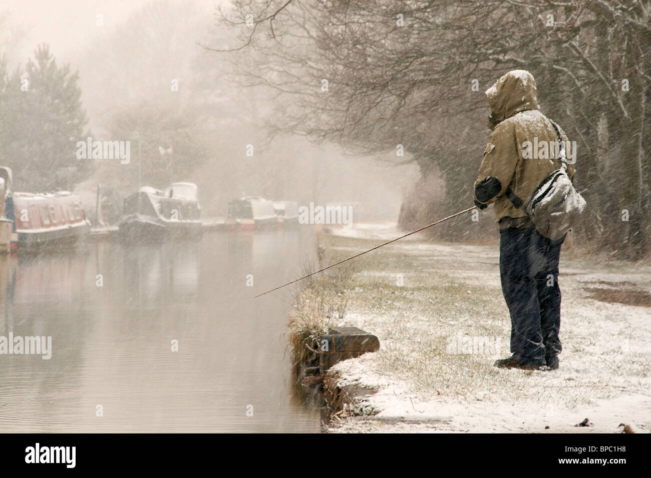 Lure fishing on the Coventry canal in the snow. Stock Photo