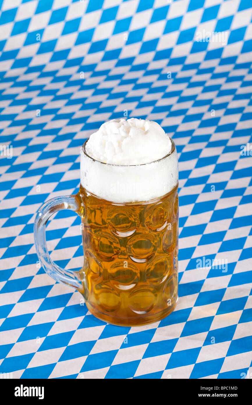 Full Oktoberfest beer stein and Bavarian flag in background Stock Photo