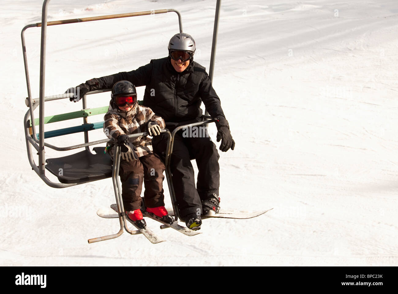 red deer, alberta, canada; a father and son on a chair lift at a ski