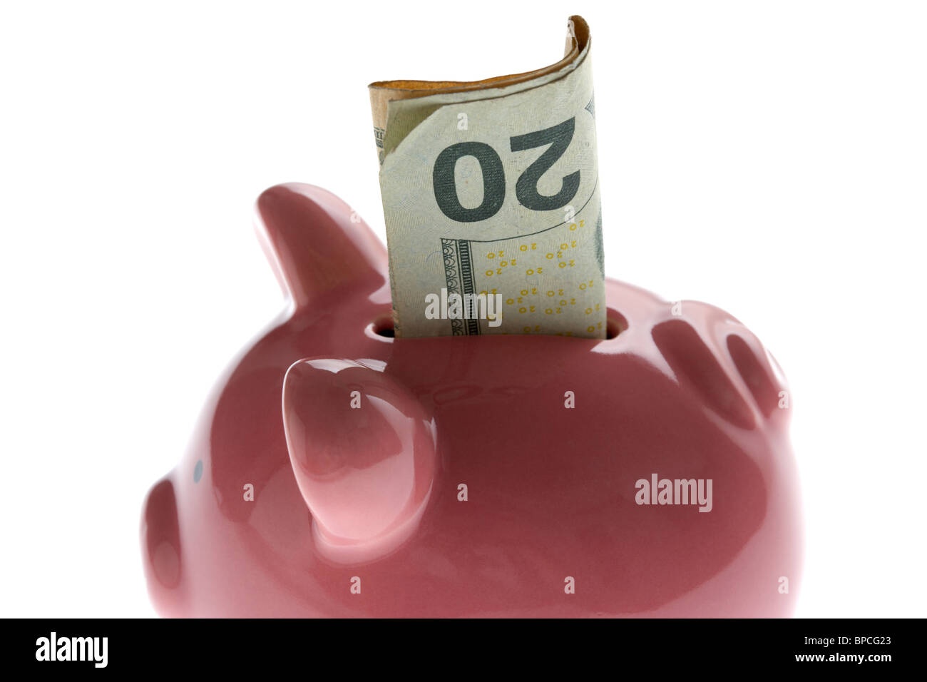 pink piggy bank with 20 dollar note on white background Stock Photo