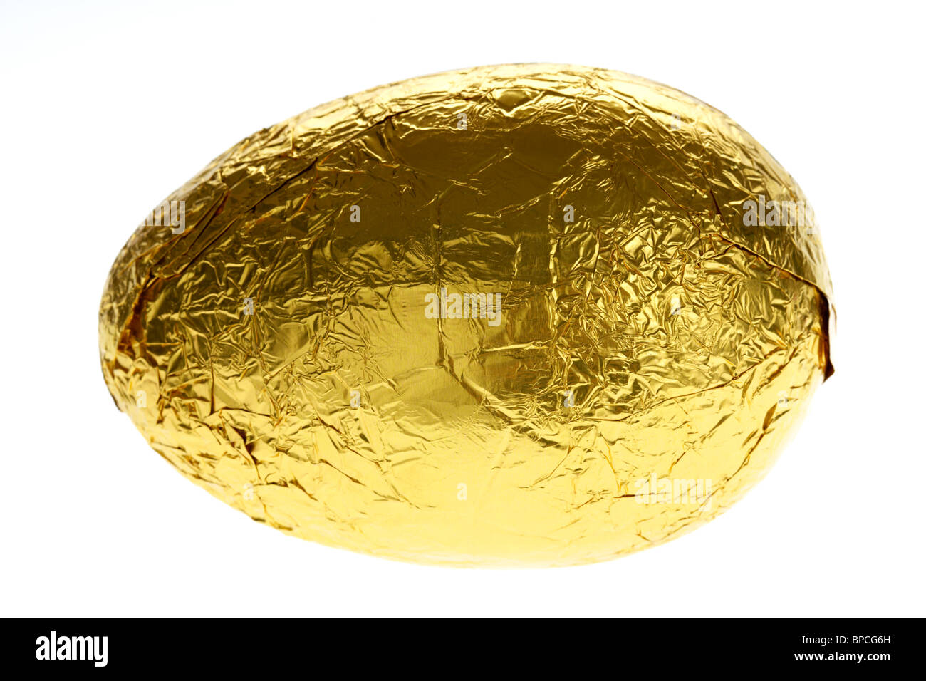 gold foil wrapped chocolate easter egg on white Stock Photo Alamy