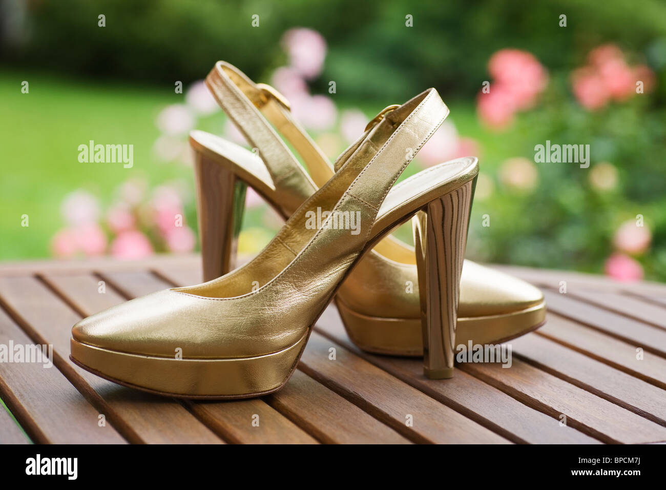 Pair of woman high heel shoes on the board outdoors Stock Photo