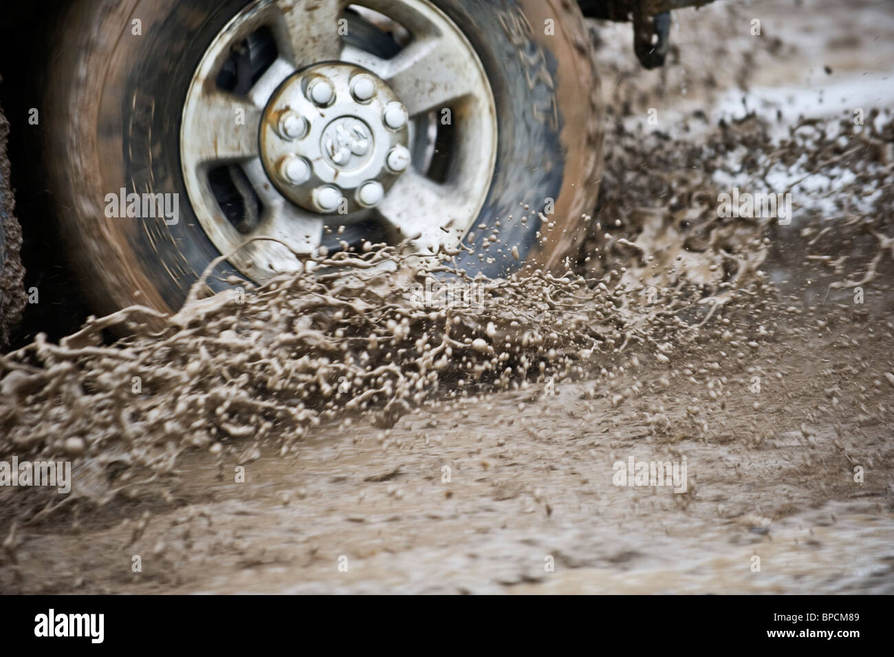 An image of a truck wheel and tire spinning through a mud hole Stock Photo Alamy