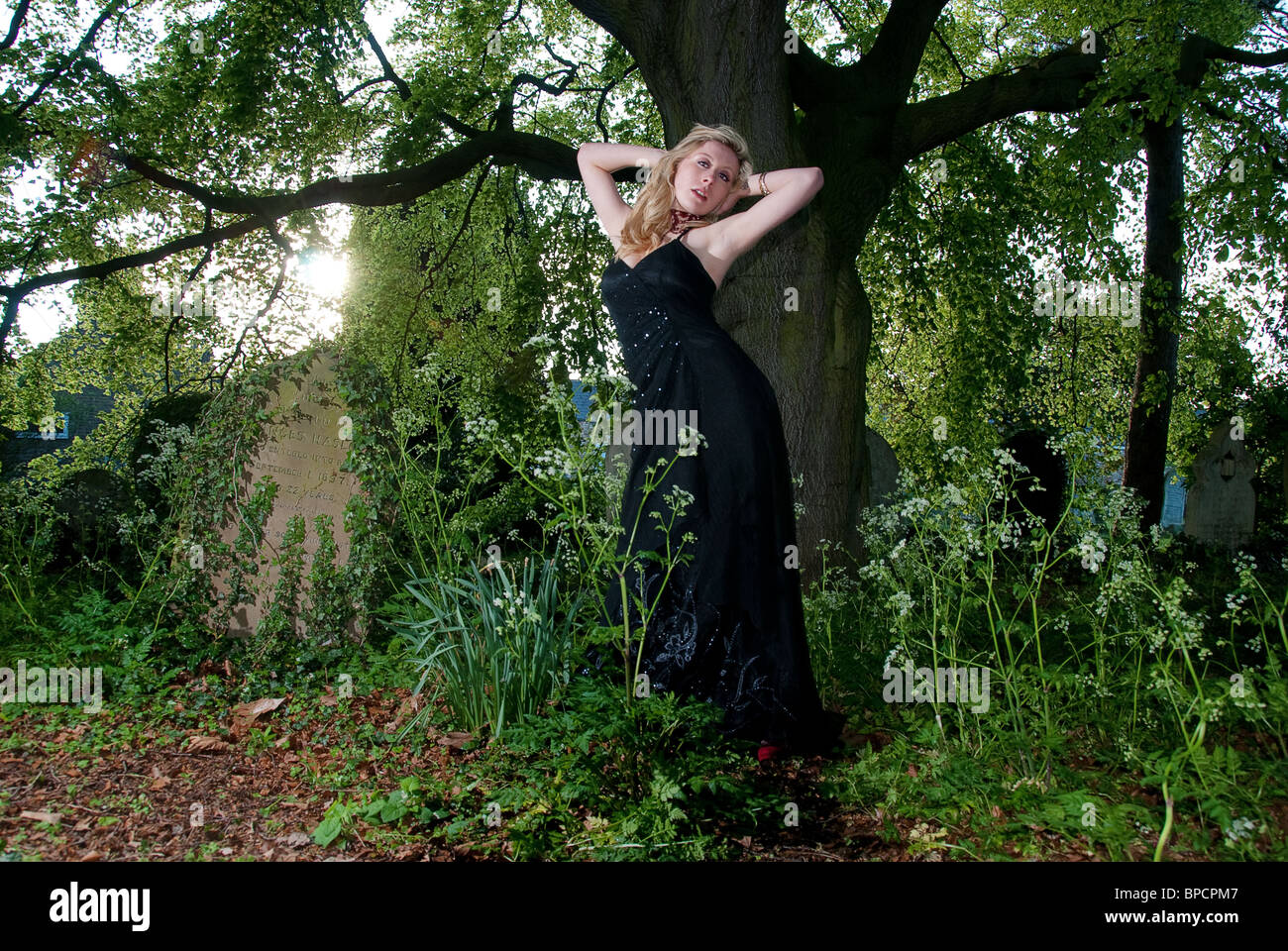 girl in black dress in the woods Stock Photo