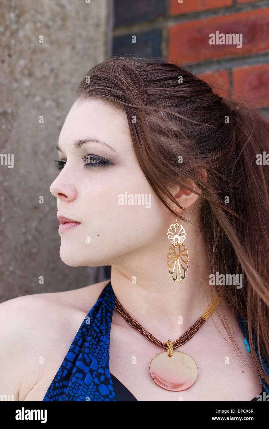 Woman wearing gold earrings hi-res stock photography and images - Alamy