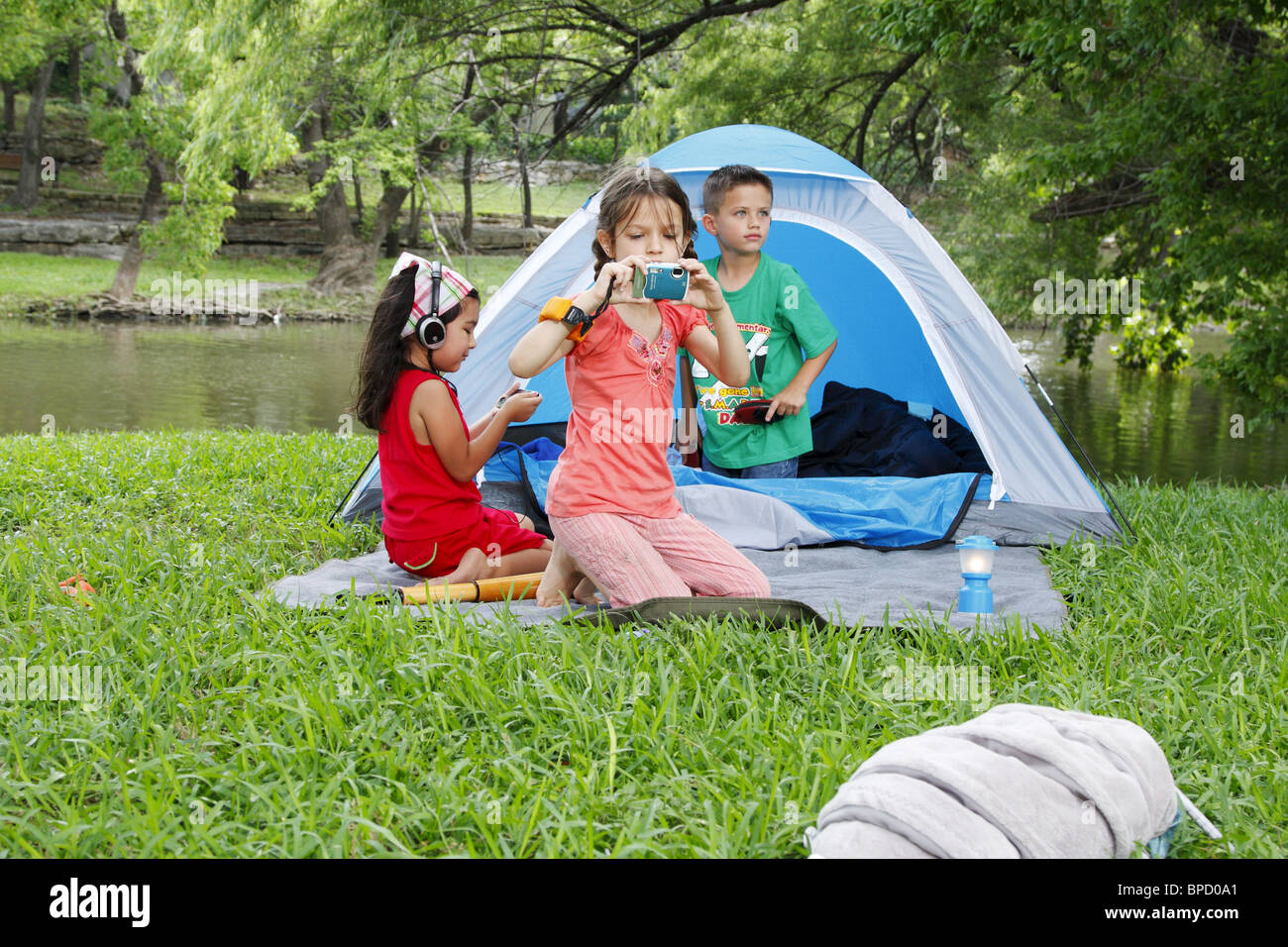 kids using electronics while camping Stock Photo