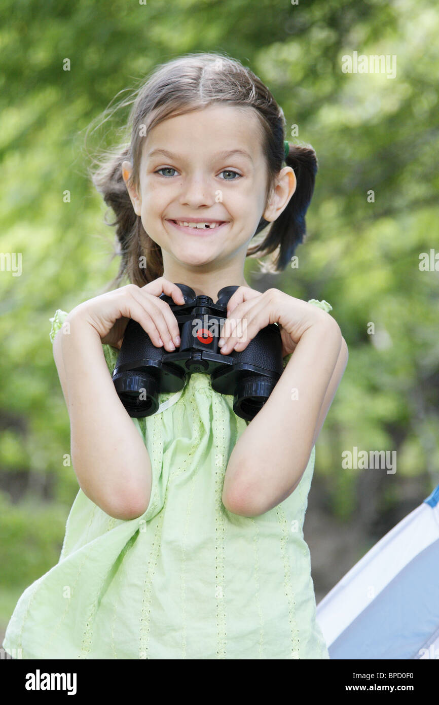 Cute kid smiling holding binoculars. Stock Photo