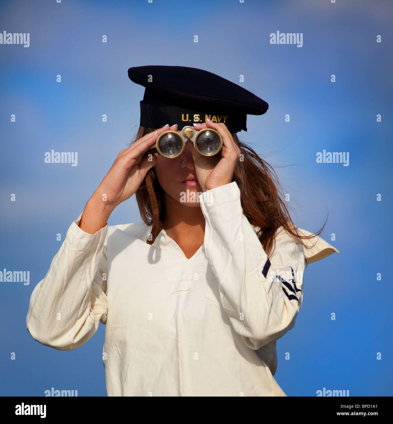 Young woman in the Navy looking through binoculars Stock Photo