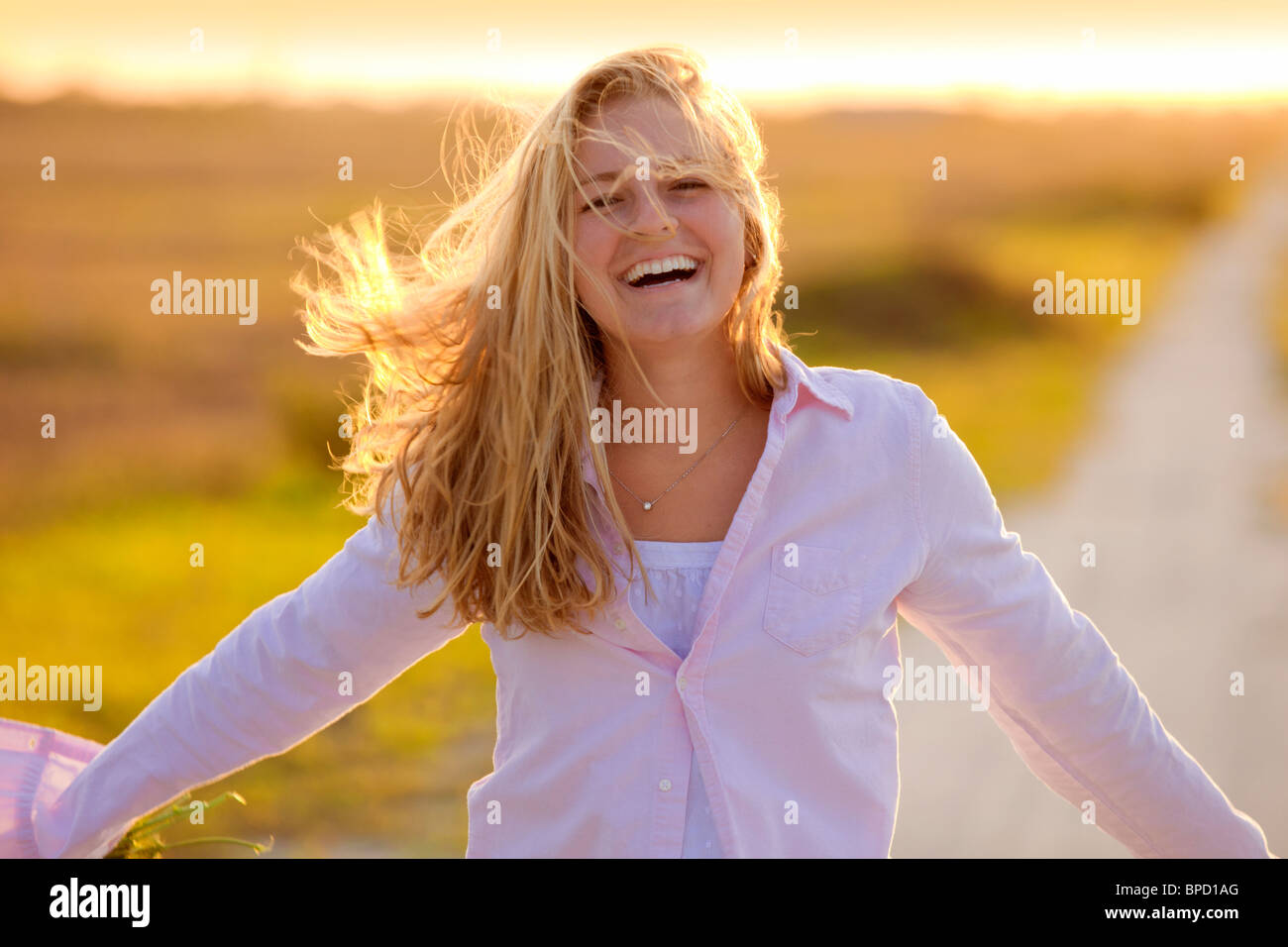 Young happy woman standing on country road Stock Photo