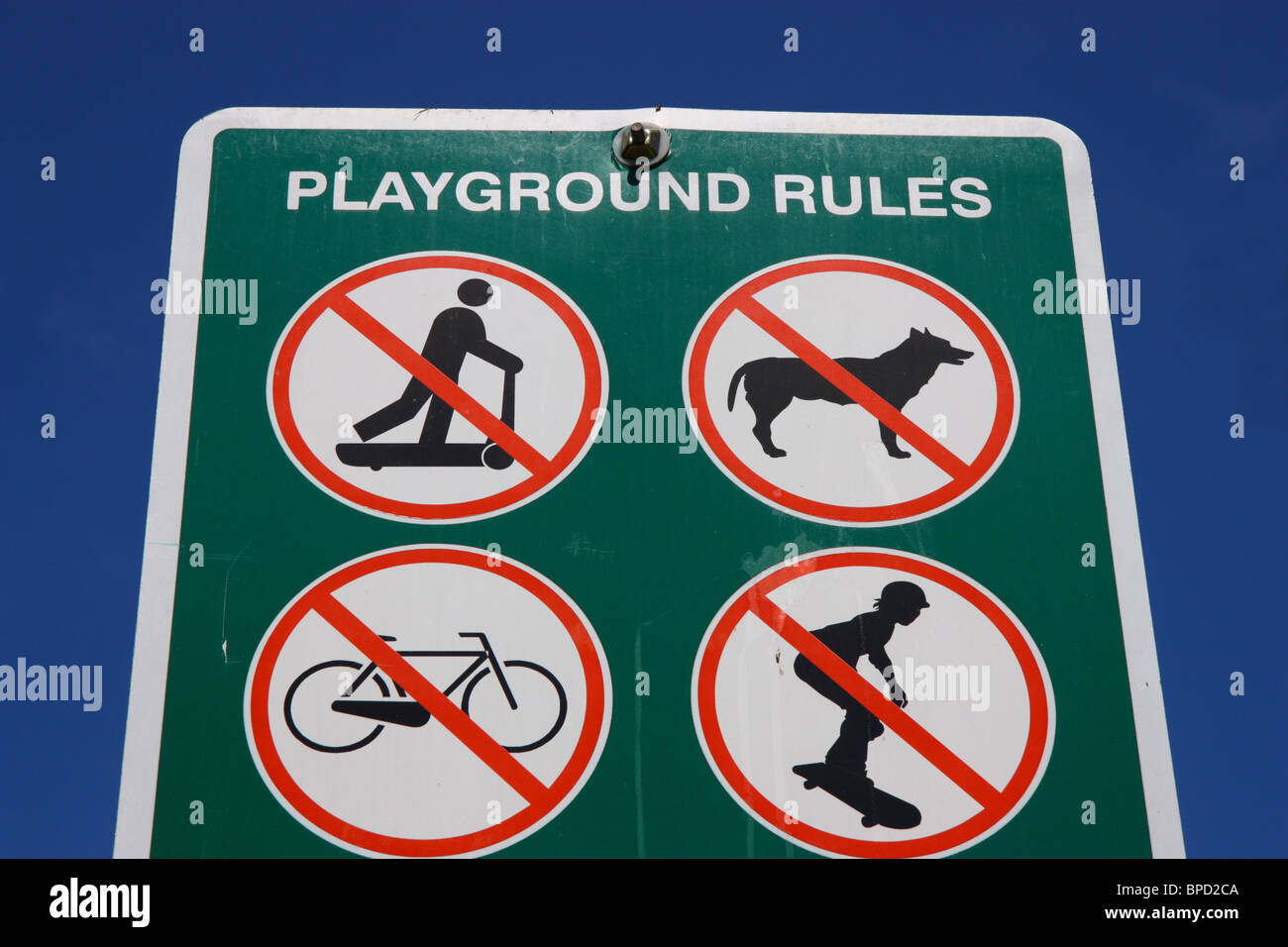 Sign at a playground forbidding scooters, skateboards, dogs, and bicycles Stock Photo