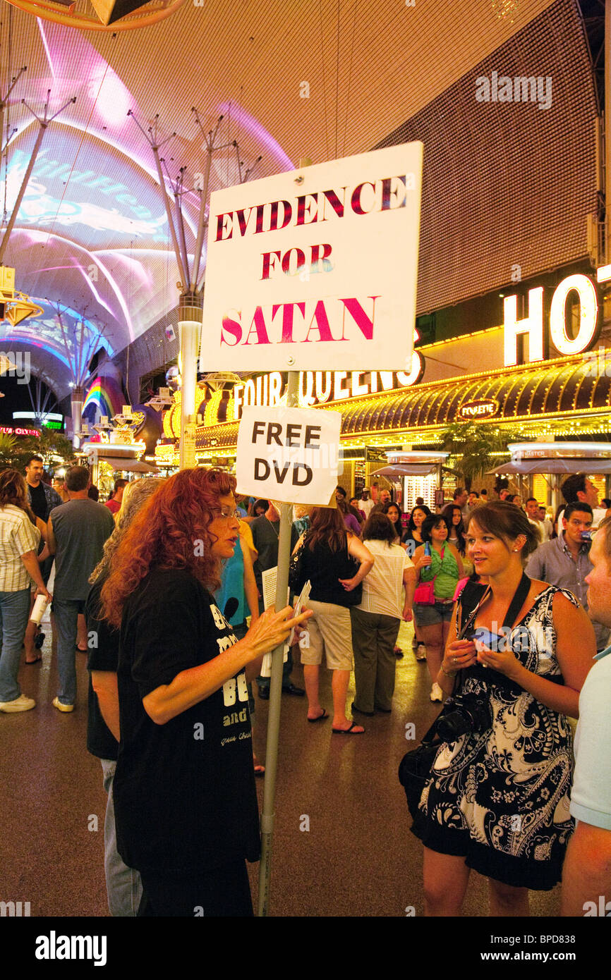 A woman handing out free DVDs about 'Evidence for Satan', Fremont St, Las Vegas, Nevada USA Stock Photo
