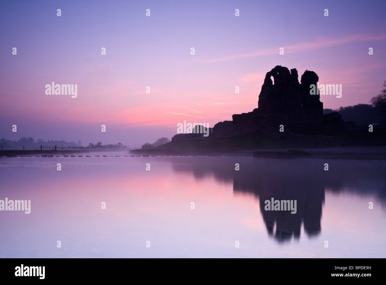 Sunrise over Ogmore Castle on a calm misty spring morning. Stock Photo