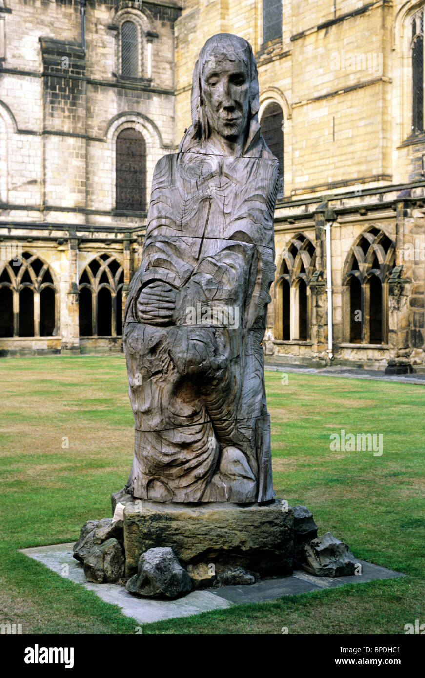 Durham Cathedral cloisters, modern statue of St. Cuthbert England UK English saint saints elm wood carving carvings sculptures Stock Photo