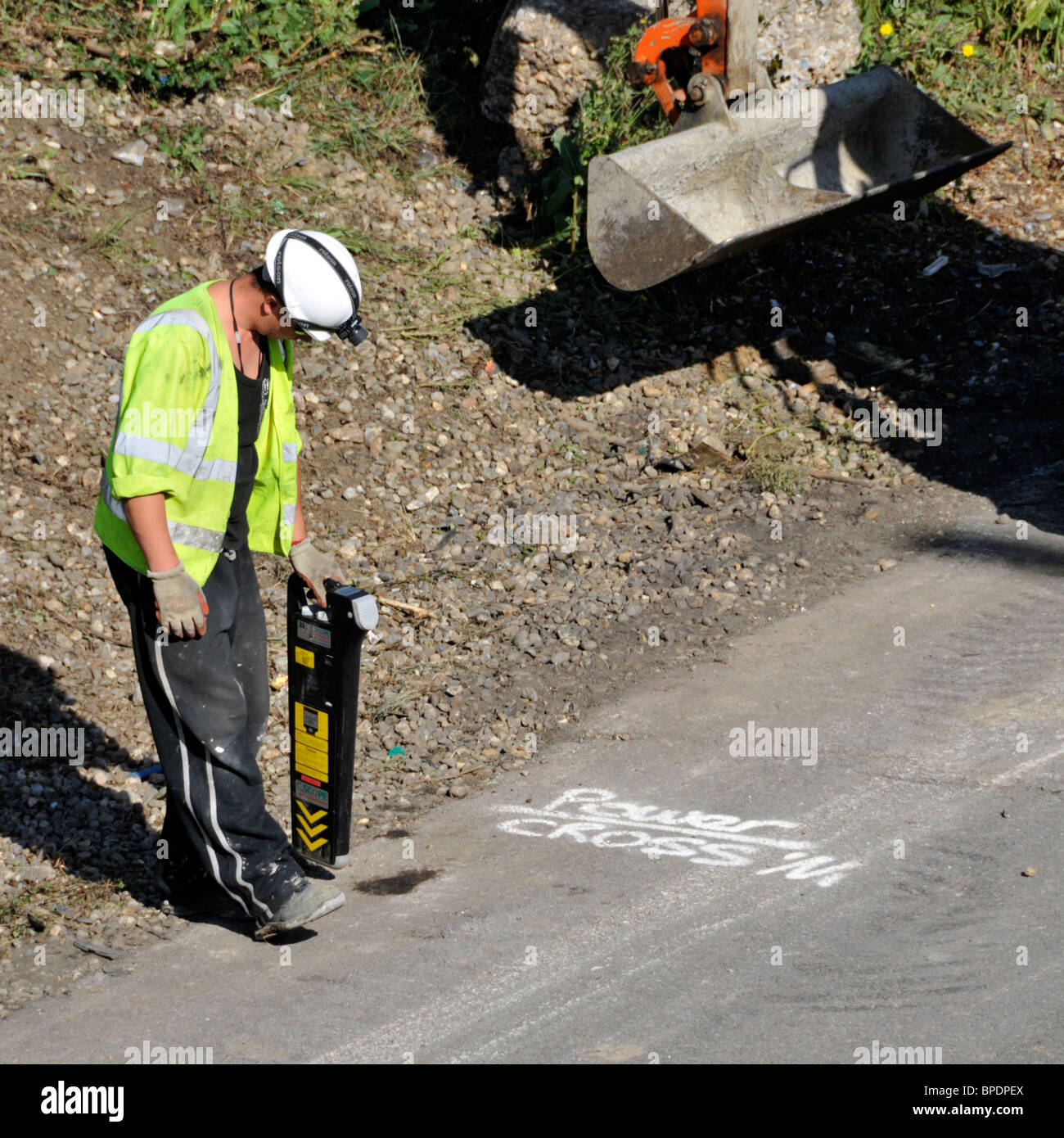 Road works M25 motorway hard shoulder workman using  hand held Scope pipe & cable locator gadget before digger starts work Brentwood Essex England UK Stock Photo
