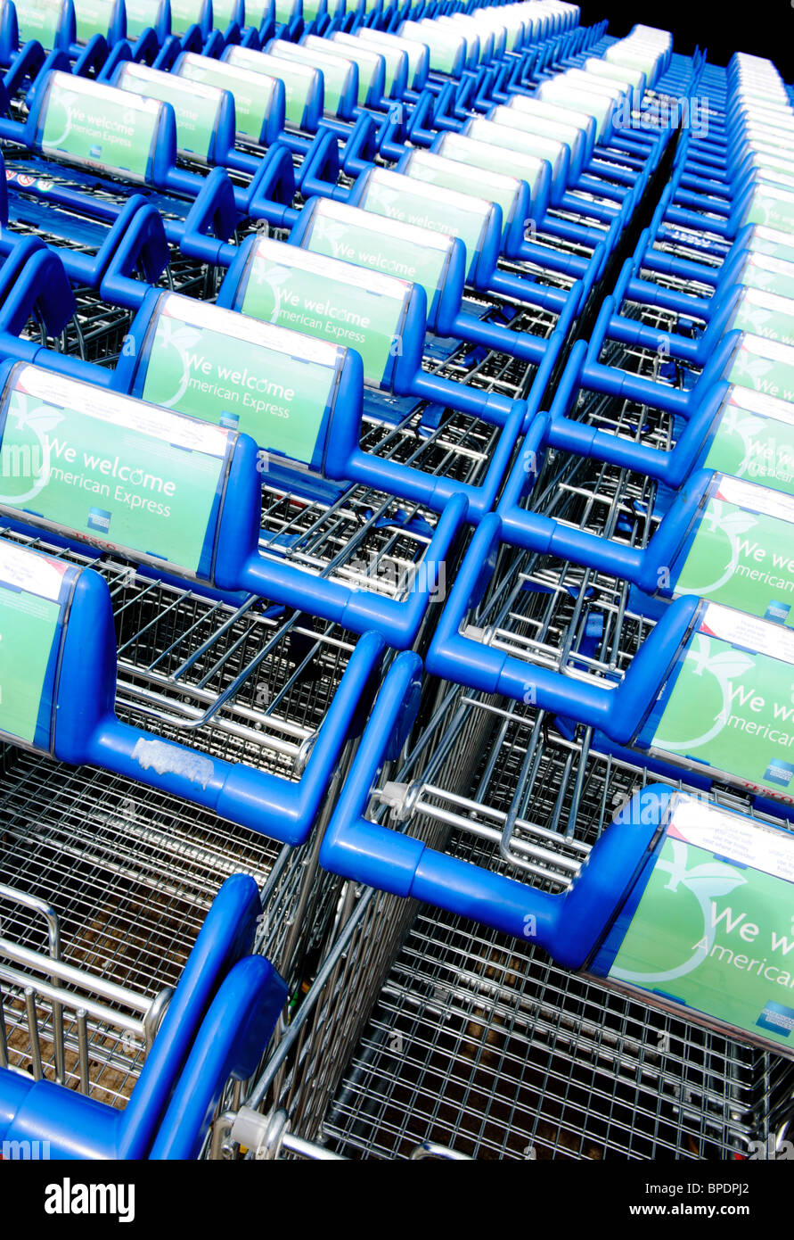 Several shoppings trolleys parked up in a line outside a Tesco supermarket Stock Photo