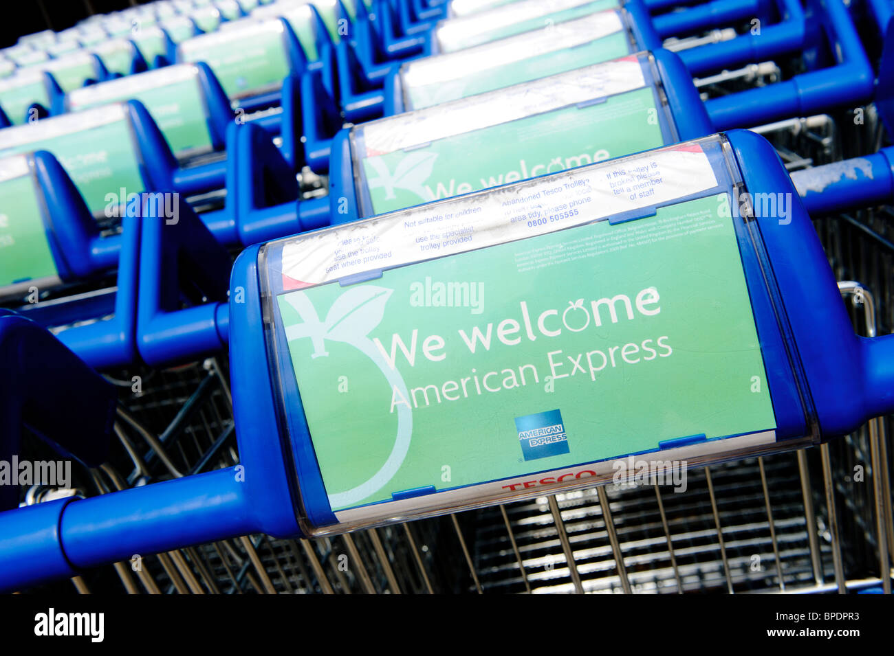 Several shoppings trolleys parked up in a line outside a Tesco supermarket Stock Photo